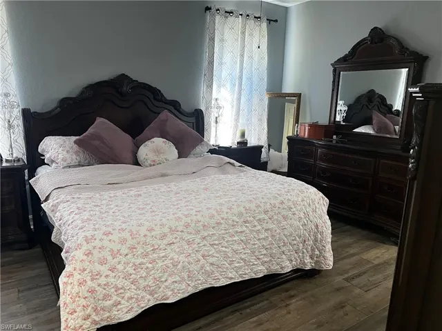 Bedroom with dark wood-style flooring