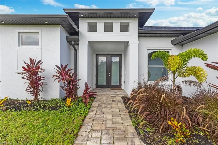 Property entrance with french doors and stucco siding