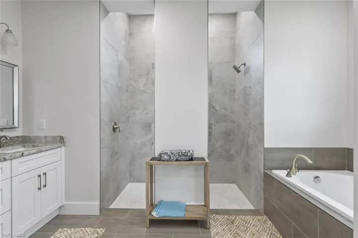 Bathroom with vanity, walk in shower, and a bath