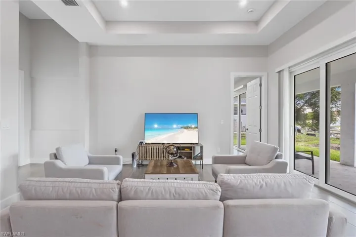 Living room featuring a tray ceiling and recessed lighting