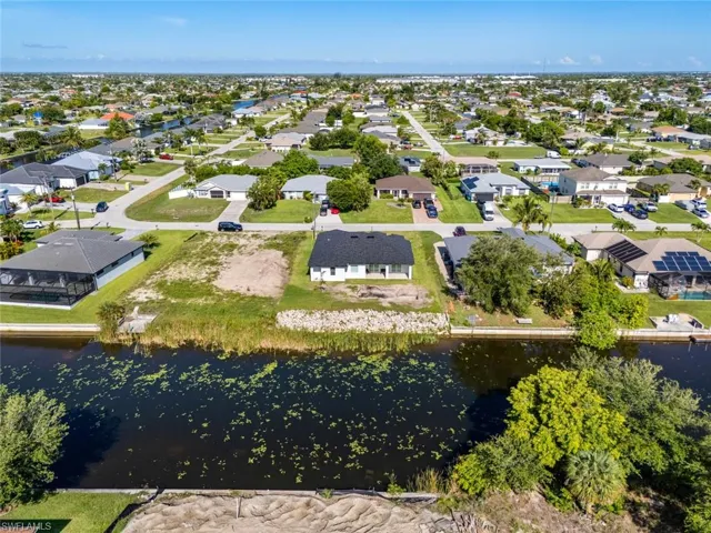 Aerial perspective of suburban area featuring a nearby body of water