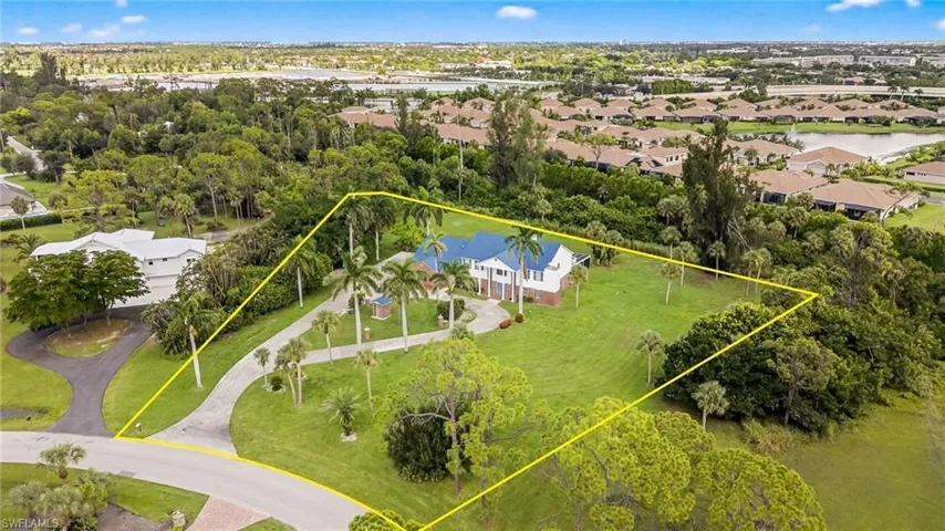 Aerial perspective of suburban area with a nearby body of water and property boundaries highlighted