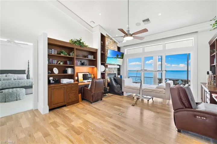 Home office featuring ceiling fan, a fireplace, light wood-style floors, recessed lighting, and ornamental molding
