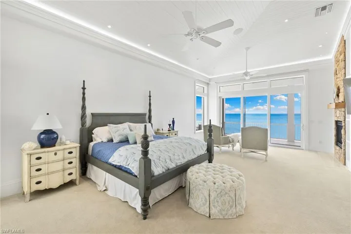 Bedroom with carpet flooring, ceiling fan, access to outside, a stone fireplace, and recessed lighting