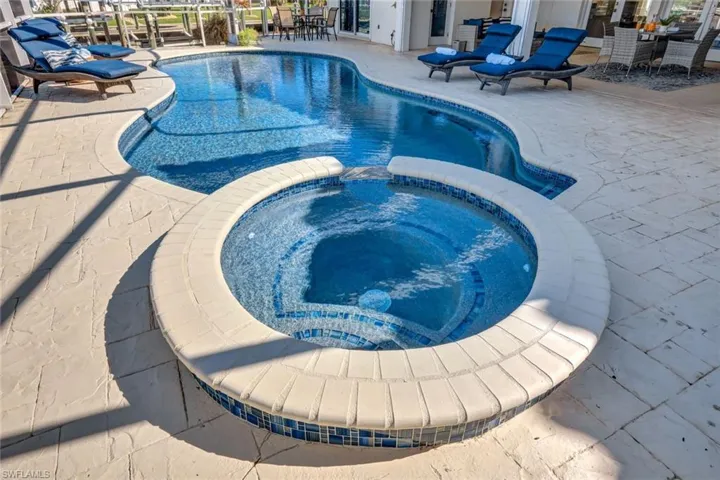 View of swimming pool featuring an in ground hot tub and a patio