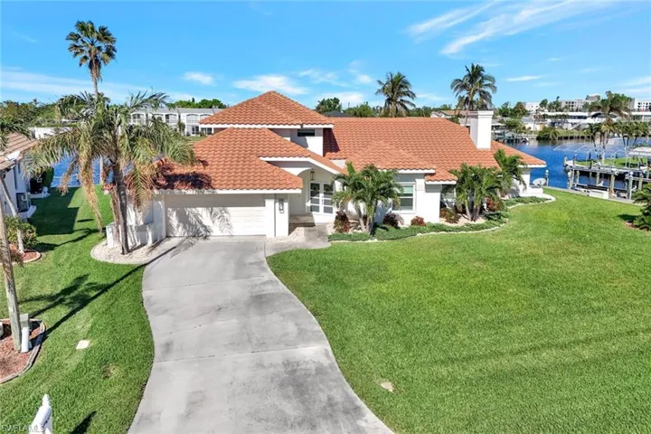 Mediterranean / spanish home with a water view, a garage, and a front lawn