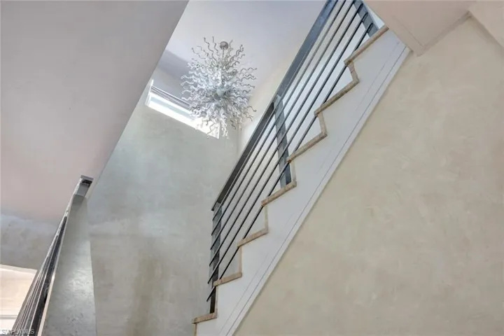 Stairs featuring concrete flooring and a high ceiling