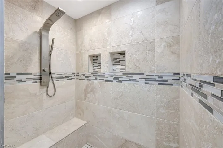 Bathroom with a tile shower and tile walls