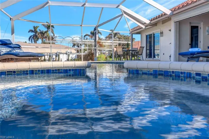 View of swimming pool featuring glass enclosure