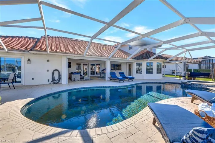 View of pool with glass enclosure, an in ground hot tub, a patio, and french doors
