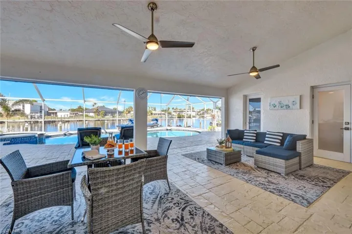 View of patio featuring a fenced in pool, glass enclosure, a water view, and an outdoor hangout area