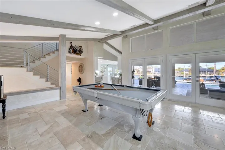 Game room featuring beamed ceiling, french doors, a healthy amount of sunlight, and billiards