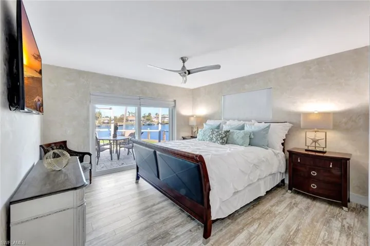 Bedroom featuring access to exterior, light hardwood / wood-style flooring, and ceiling fan