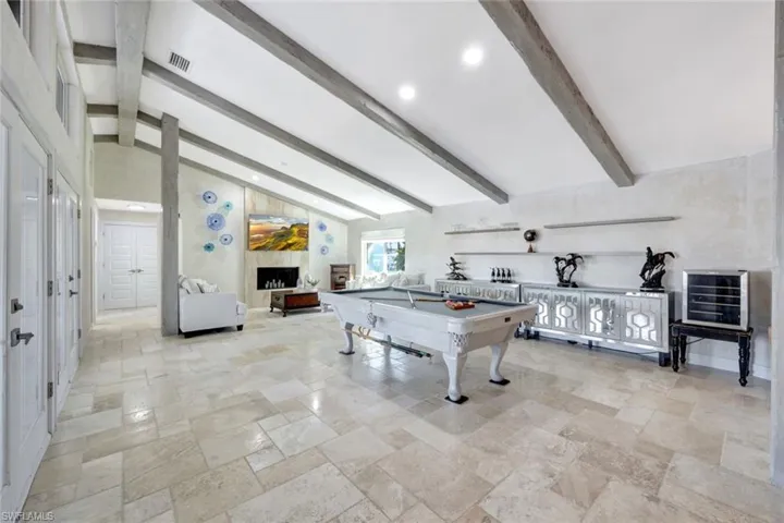 Recreation room with lofted ceiling with beams and pool table