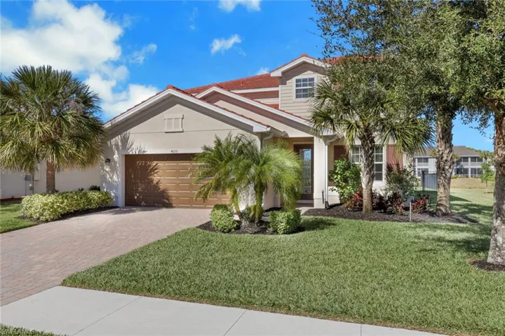 View of front facade with a front yard, decorative driveway, stucco siding, and an attached garage