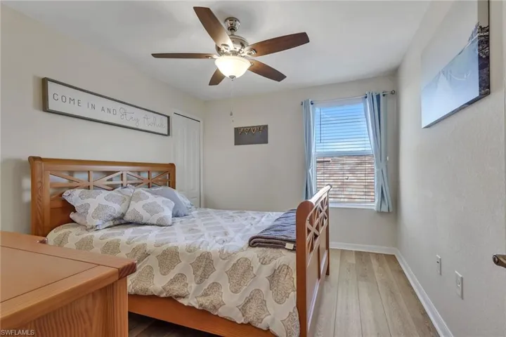 Bedroom with light wood-style flooring, a ceiling fan, and a closet