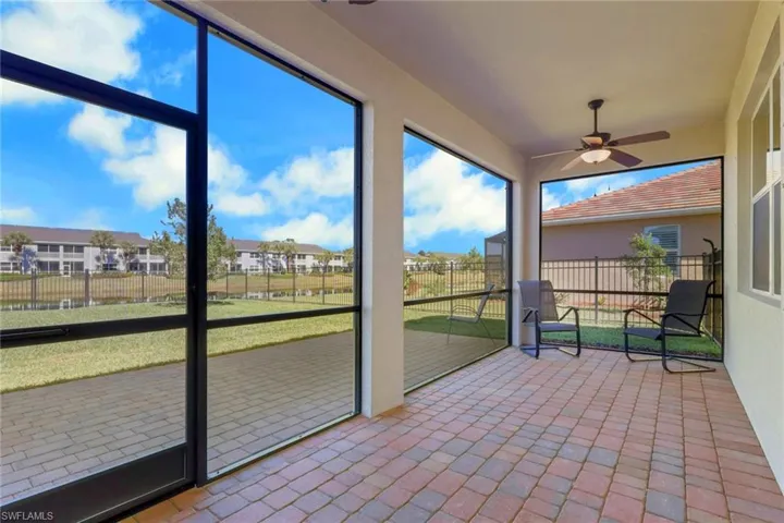 Unfurnished sunroom featuring ceiling fan and a residential view