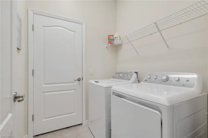 Laundry room with washer and dryer and light tile patterned floors