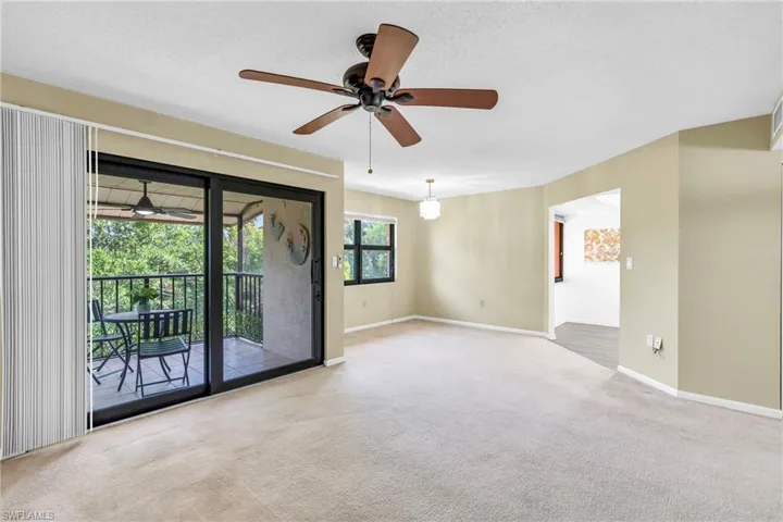 Empty room with carpet, a textured ceiling, and ceiling fan
