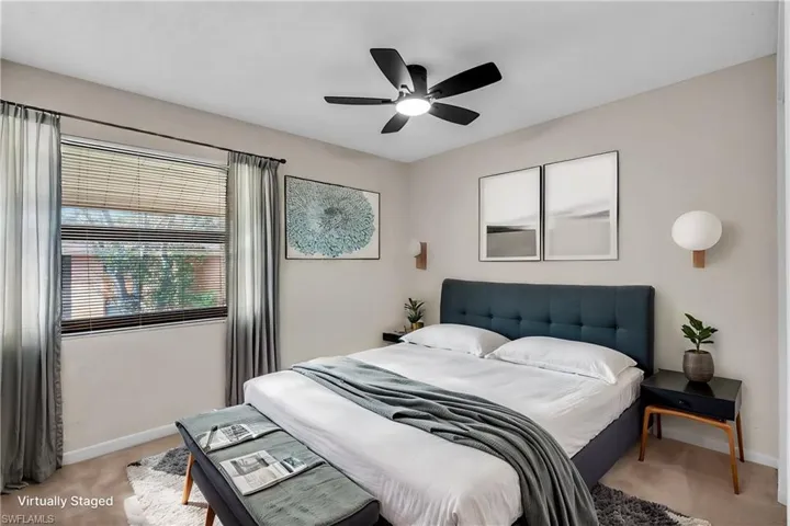 Carpeted bedroom featuring ceiling fan