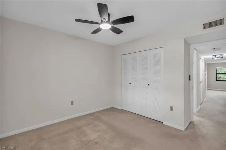Unfurnished bedroom with ceiling fan, light colored carpet, and a closet