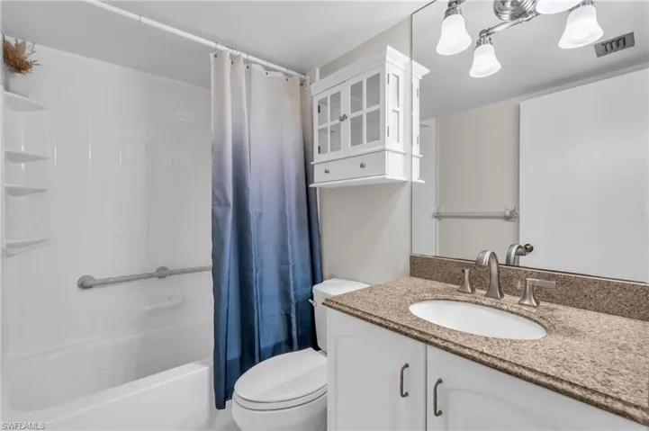 Full bathroom with vanity, toilet, and shower / tub combo with curtain