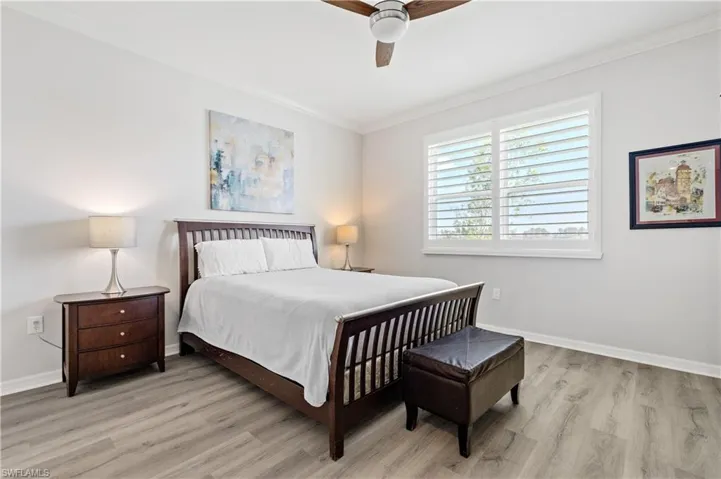 Bedroom featuring crown molding, wood finished floors, and baseboards