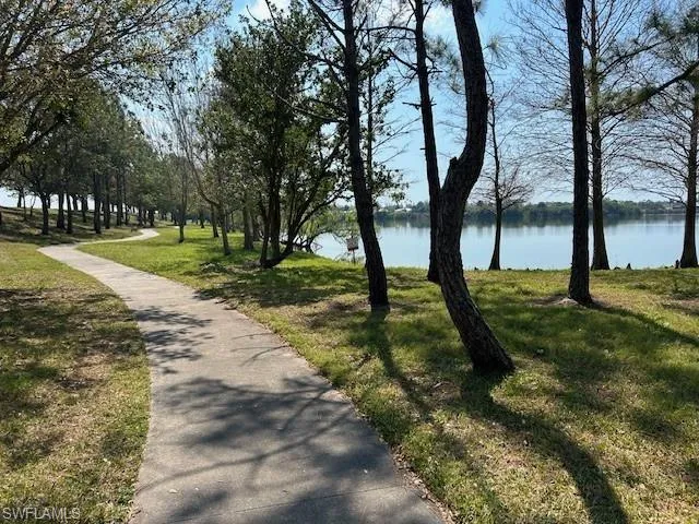 View of home's community with a lawn and a water view