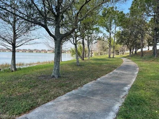 View of property's community with a water view and a lawn