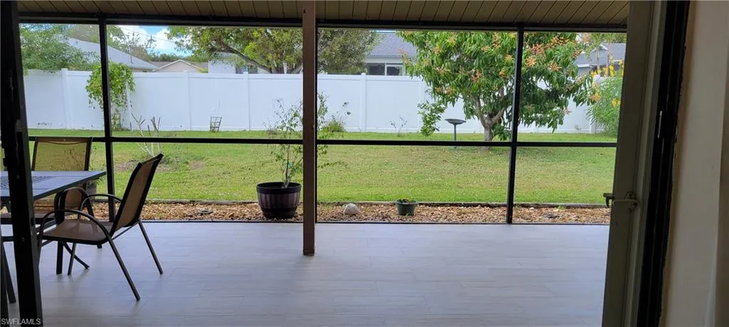 View onto the screened patio and the fully fenced yard.  New tile has just been completed!