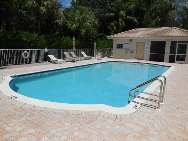 Community pool with a patio area and an outdoor structure