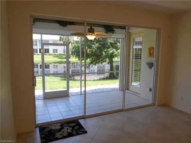 Entryway with a ceiling fan, a water view, and tile patterned floors