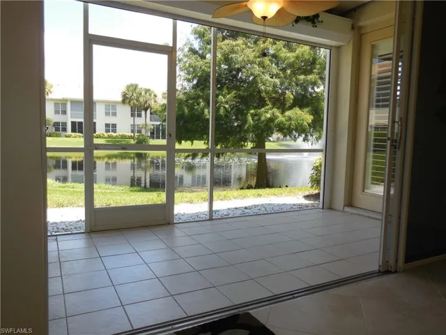 Doorway to outside featuring tile patterned flooring, ceiling fan, and a water view
