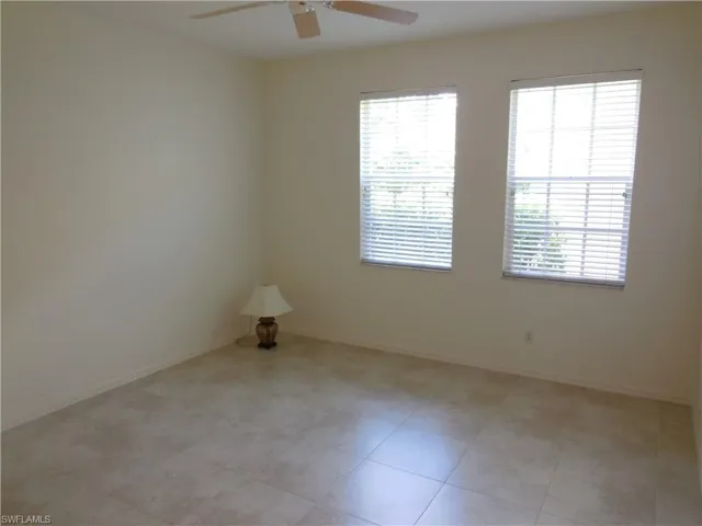 Spare room featuring a ceiling fan and baseboards