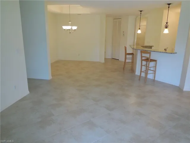 Unfurnished room featuring a chandelier