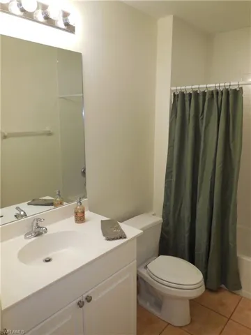 Full bathroom featuring vanity, light tile patterned flooring, and shower / tub combo with curtain