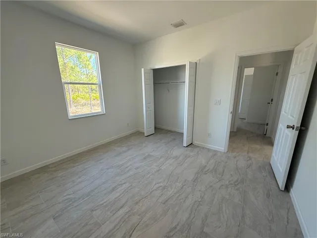 Unfurnished bedroom featuring baseboards and a closet