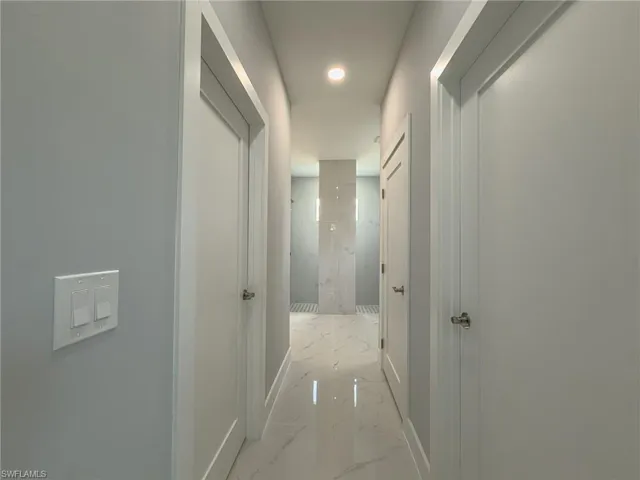 Hall featuring recessed lighting, marble finish floor, and baseboards