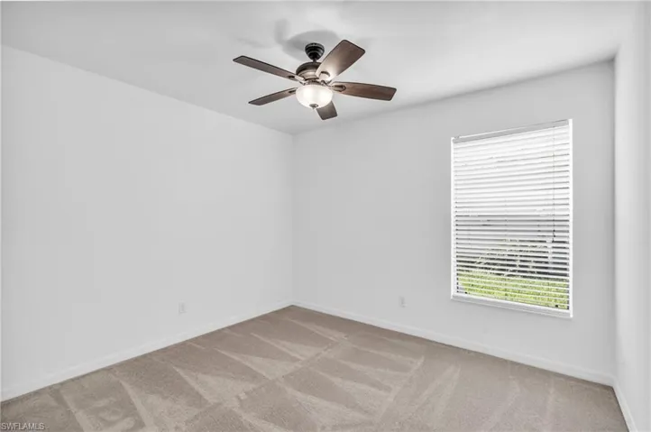 Unfurnished room featuring light colored carpet and ceiling fan