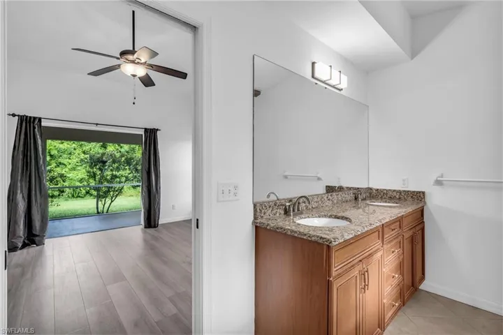 Bathroom with vanity, ceiling fan, and hardwood / wood-style floors