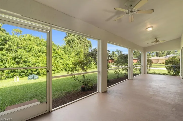 Unfurnished sunroom with ceiling fan, plenty of natural light, and vaulted ceiling