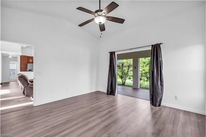 Spare room featuring ceiling fan, wood-type flooring, and vaulted ceiling