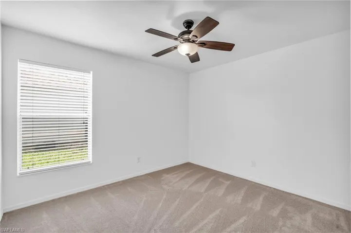 Carpeted spare room with ceiling fan
