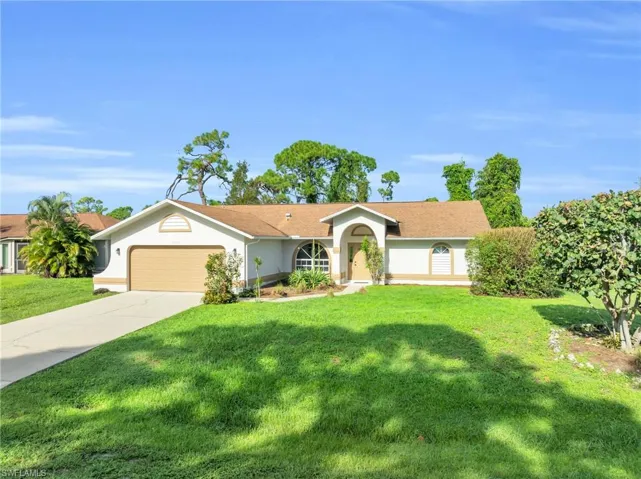 Ranch-style home with a front yard and a garage