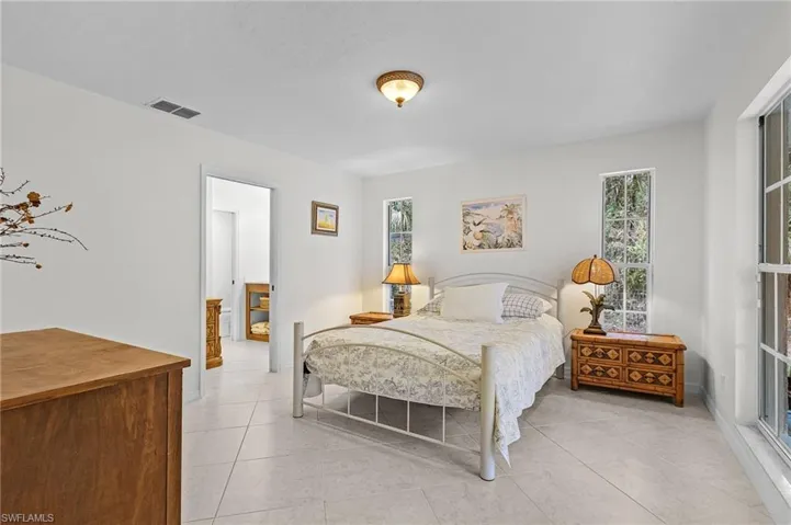 Bedroom featuring multiple windows and light tile patterned flooring