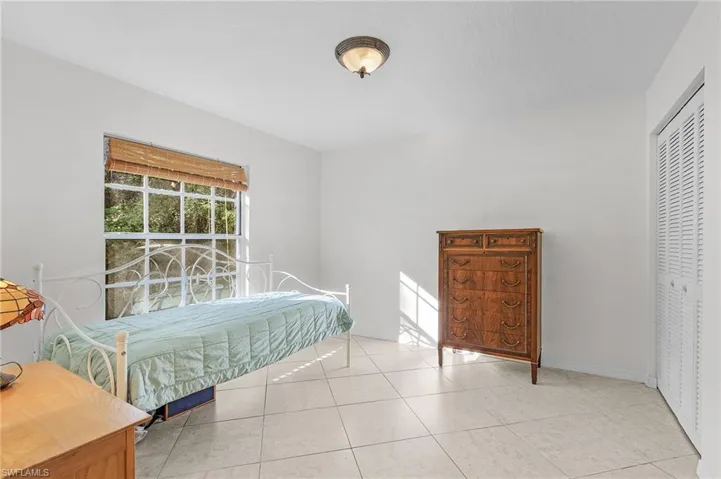 Tiled bedroom featuring a closet