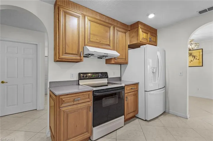 Kitchen with white appliances, and light tile patterned flooring