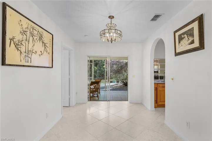 Unfurnished dining area featuring light tile patterned flooring and an inviting chandelier