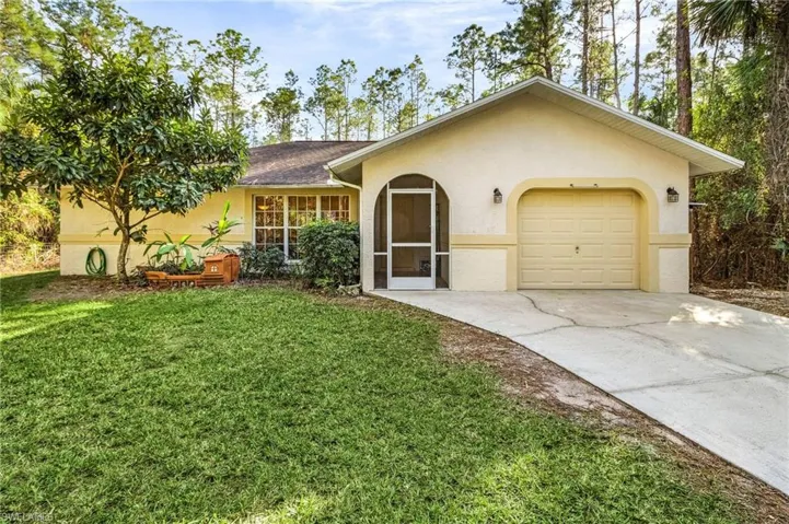 Single story home featuring a garage and a front yard