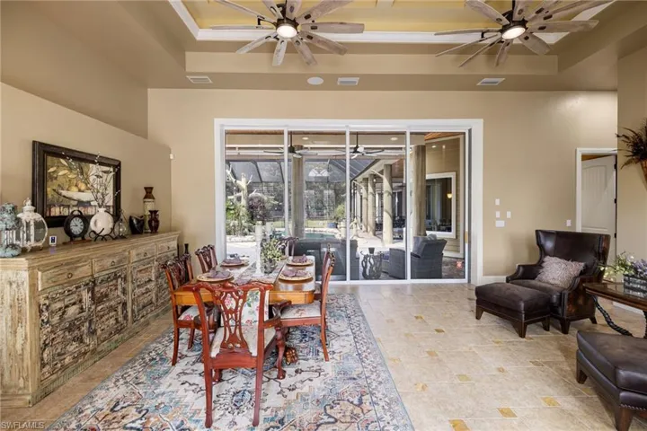 Dining room featuring a sunroom, ceiling fan, and a tray ceiling